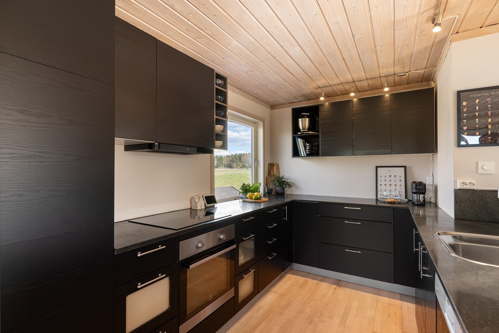Kjøkkenet fremstår som moderne og gjennomført med en mørk, minimalistisk innredning fra Kvik, som står i flott kontrast til det lyse tregulvet og taket. Galleribilde