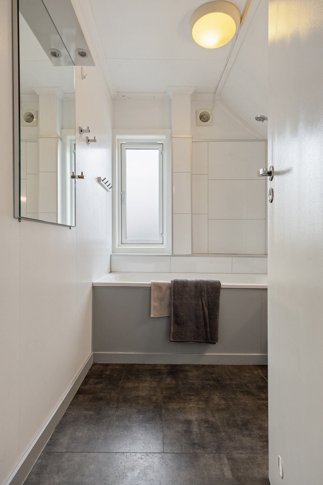 Badet har korkvinyl på gulvet og baderomsplater på deler av veggene. Galleribilde