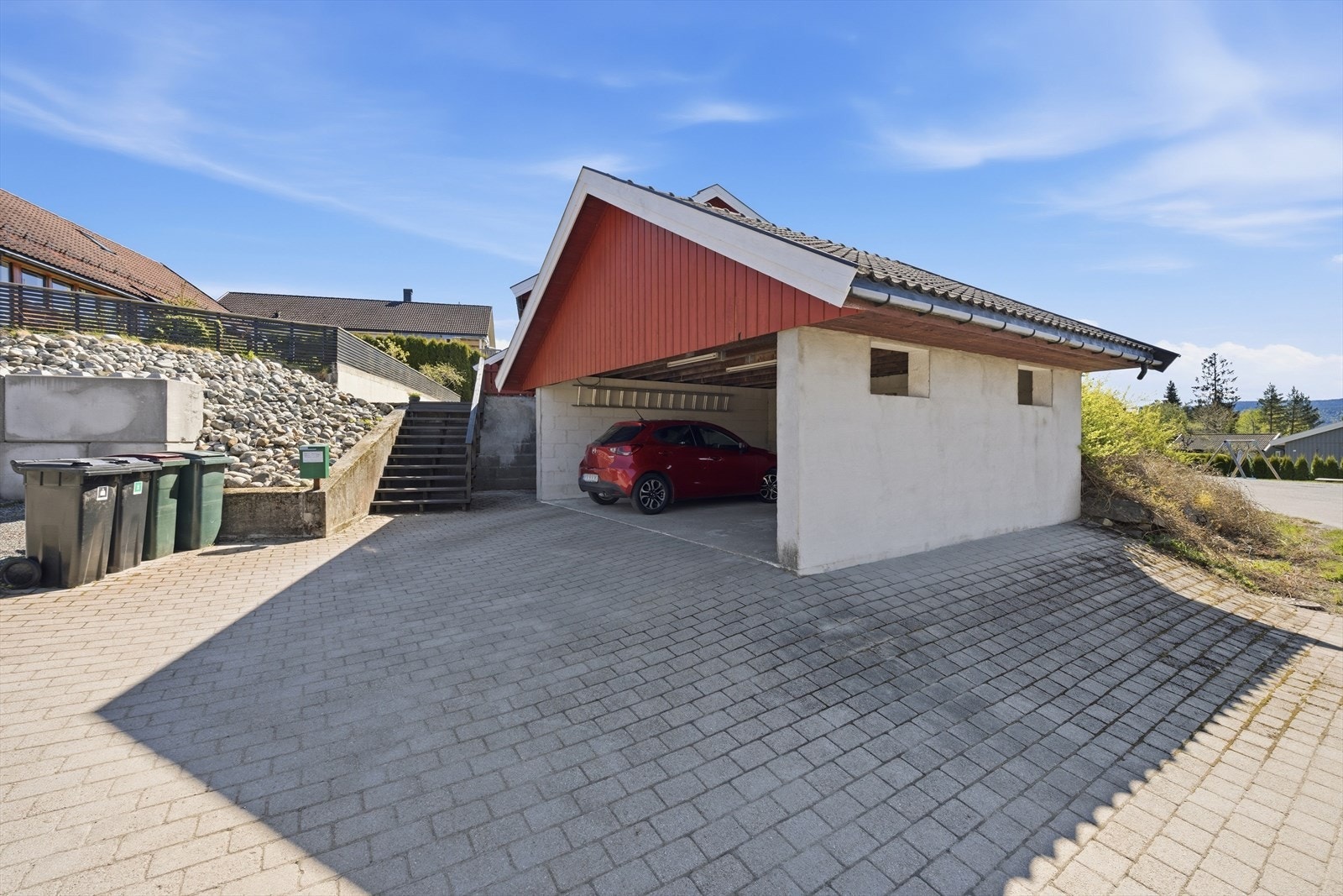Steinlagt gårdsplass med parkeringsmuligheter samt carport Galleribilde