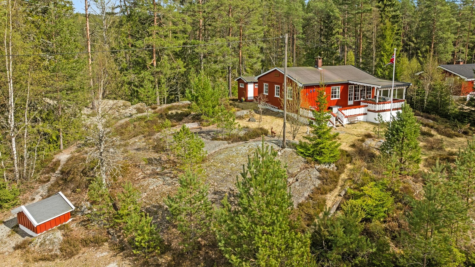 En klassisk fritidsbolig på en romslig naturtomt med svaberg. To separate boder gir rikelig med lagringsplass. Galleribilde