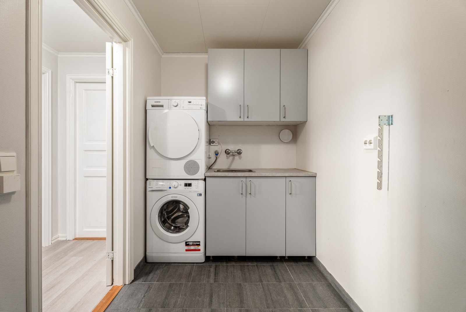Romslig vaskerom med elektriske varmekabler og opplegg for vaskemaskin. Galleribilde