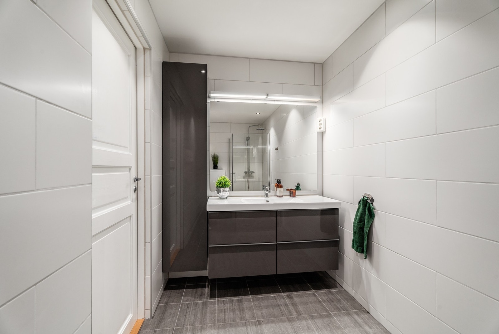 Badet har rikelig med oppbevaringsplass og fremstår i lyse, moderne farger. Galleribilde
