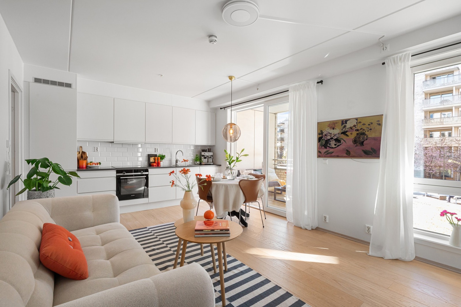 Store vindusflater som strekker seg fra taket og ned til gulvet slipper inn rikelig med naturlig lys og gir rommet en lys og behagelig karakter. Galleribilde