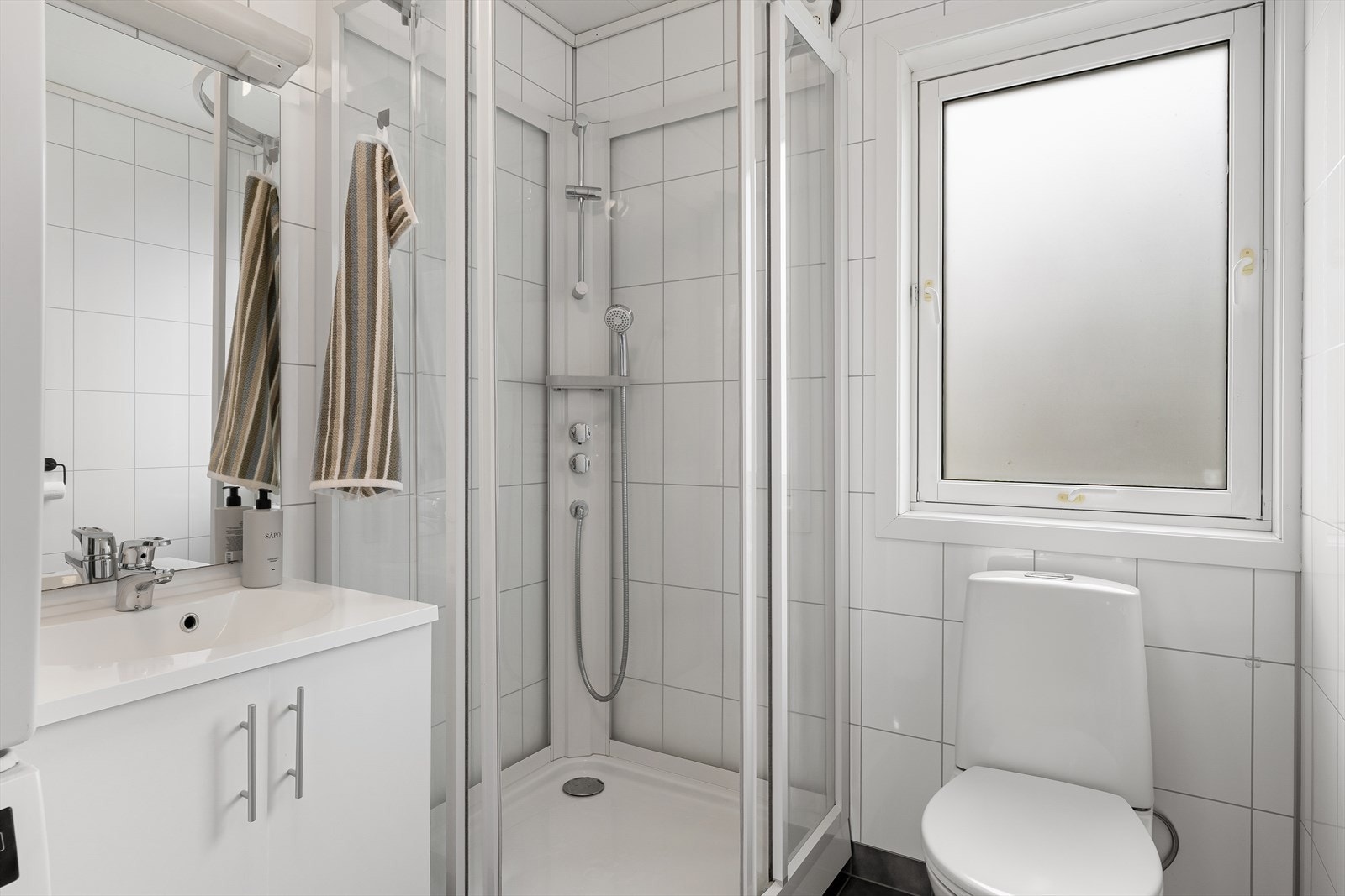 Badet er utstyrt med dusjkabinett, toalett og innredning med nedfelt servant. Galleribilde