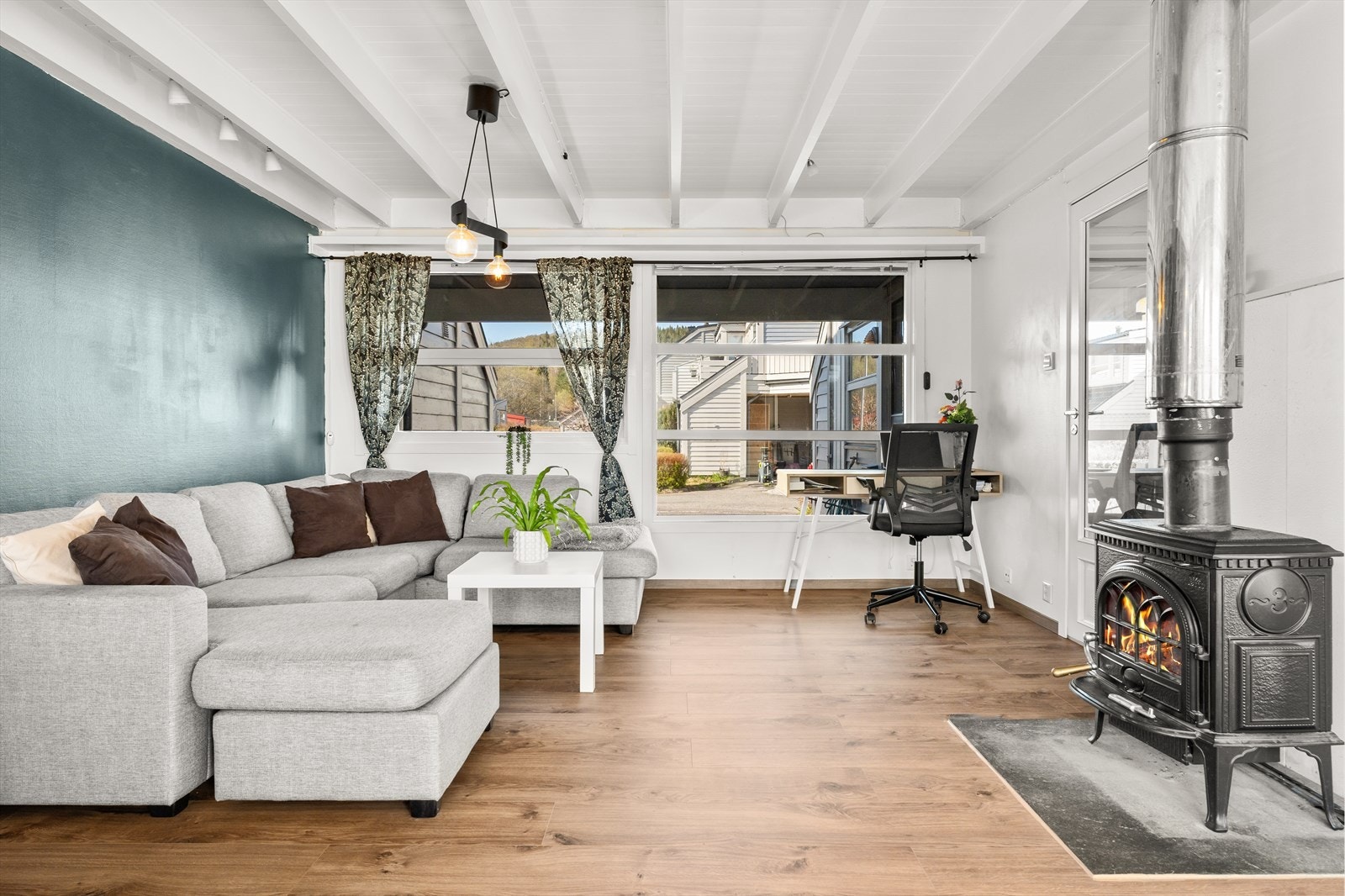 Store vindusflater gir godt med naturlig lysinnslipp og en koselig peis sørger for godt med varme på kalde dager. Galleribilde