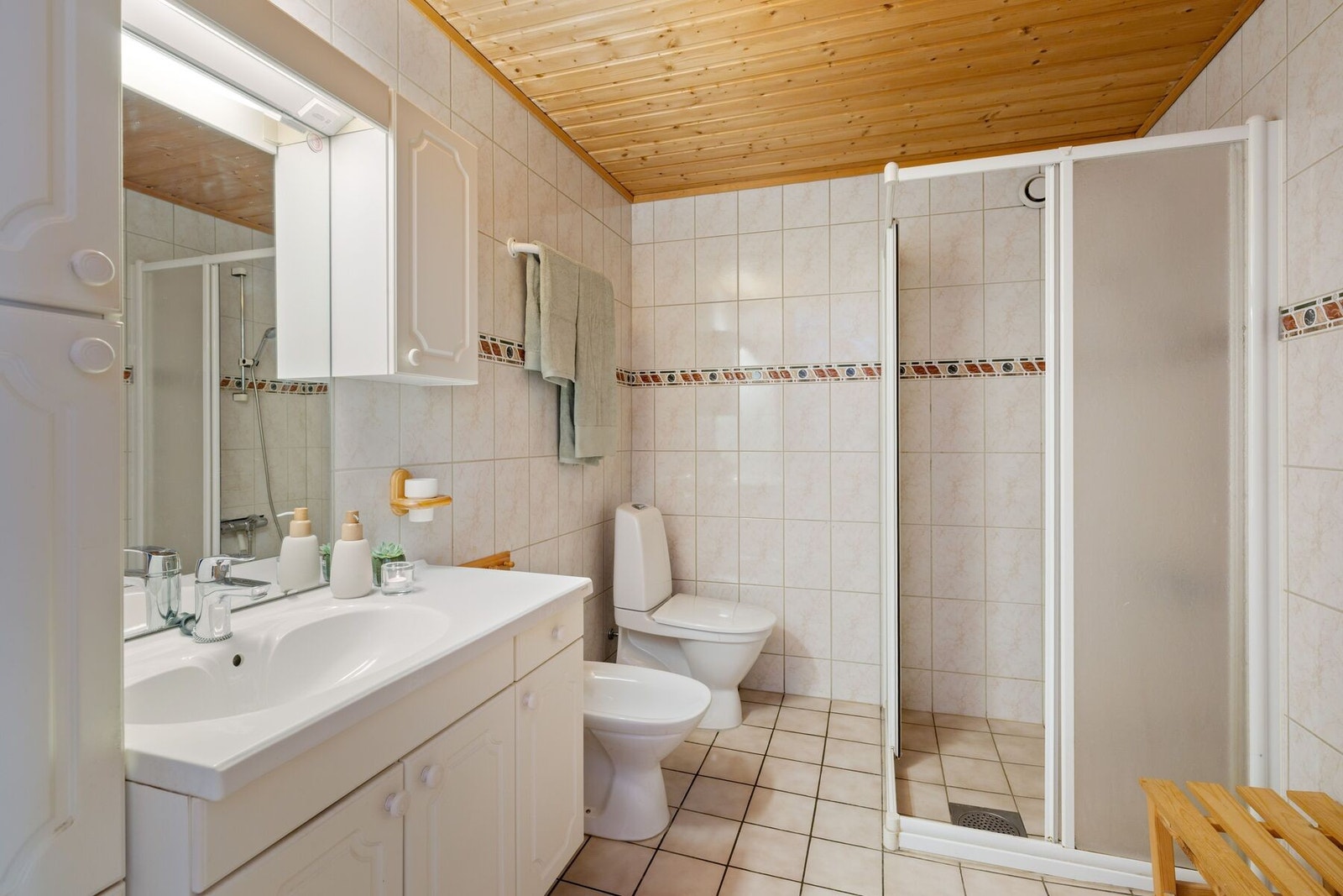 Helfliset bad i 1.etasje utstyrt med dusj, toalett, bidet, servant med innredning og varme i gulv. Galleribilde