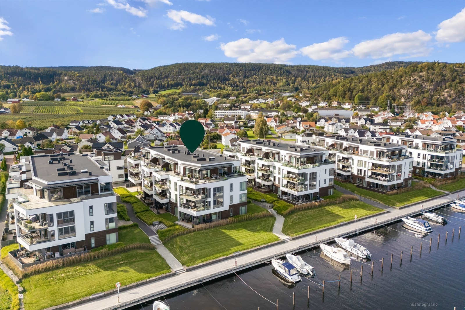 Foran bygningene er det etablert en sammenhengende fjordpromenade med småbåthavn og badeplass med sandstrand. Galleribilde