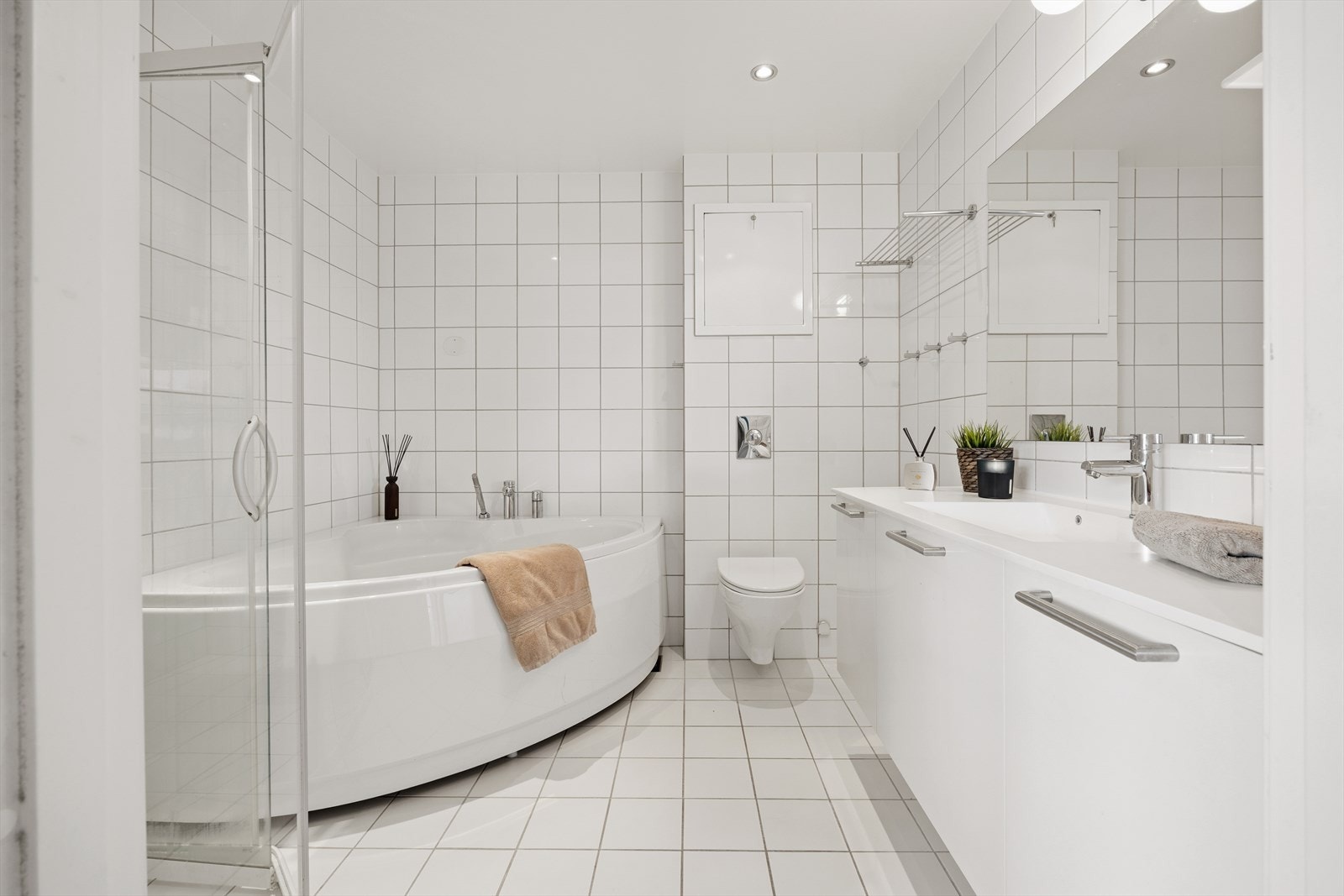 Stilfullt og klassisk bad, flislagt med badekar og romslig dusjnisje. Gulvvarme sørger for komfort i hverdagen. Galleribilde