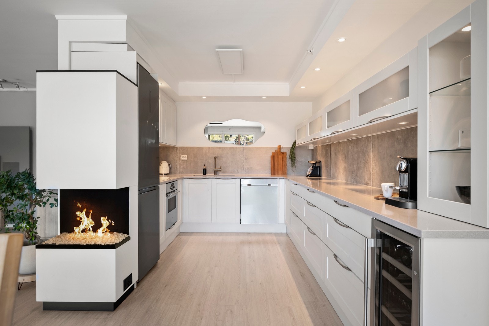 En stilren gasspeis fungerer som en naturlig og elegant romdeler inn mot stuen. Galleribilde