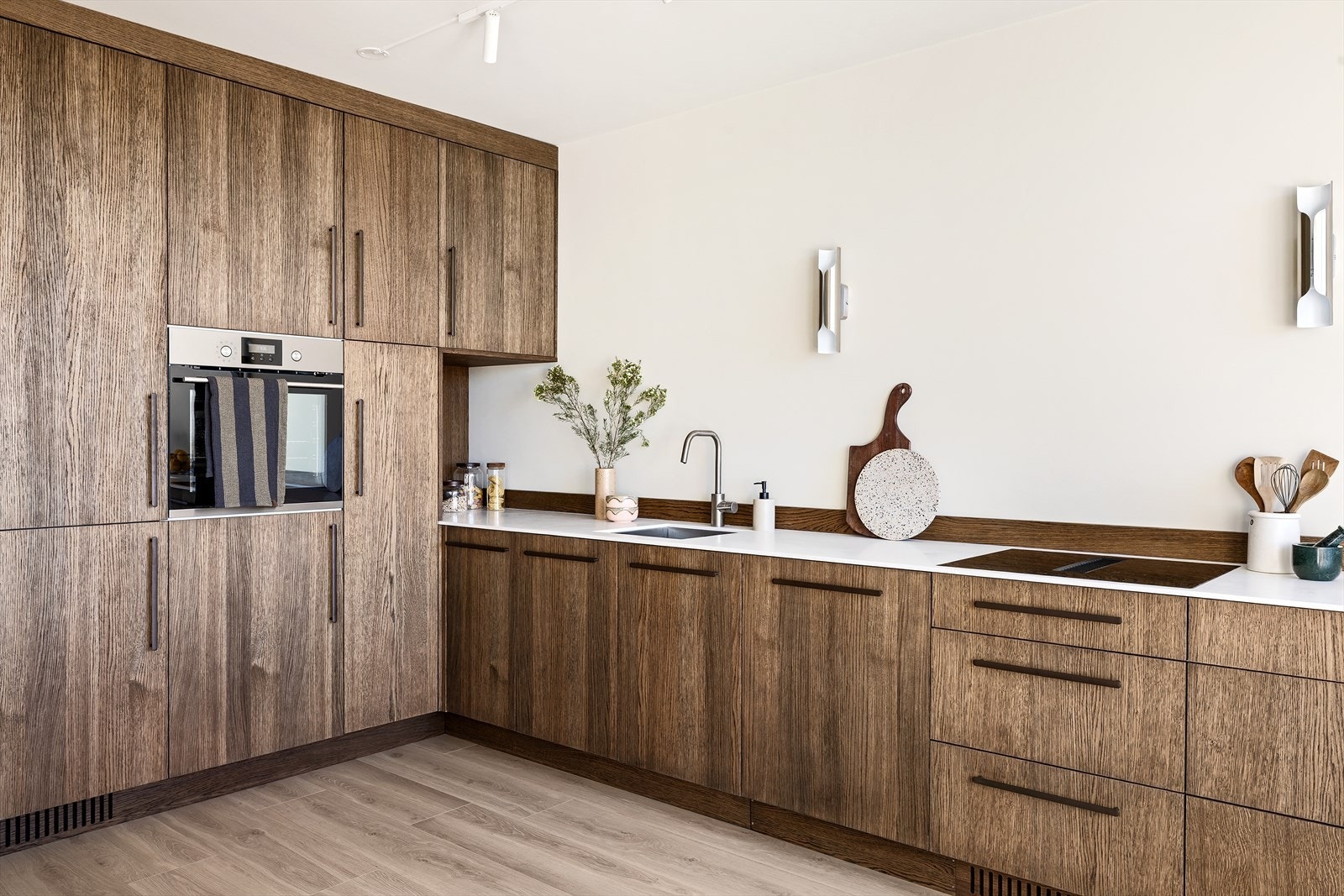 Innredningen består av både høyskap og underskap med gode oppbevaringsmuligheter, og er kombinert med en slitesterk Corian benkeplate. Det er nedfelt oppvaskkum i rustfritt stål med ettgreps svingbart blandebatteri i krom. Galleribilde