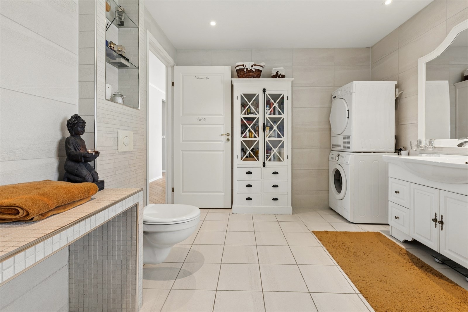 Badet har en praktisk og gjennomført utforming med vegghengt toalett og opplegg for vaskemaskin og tørketrommel. Galleribilde