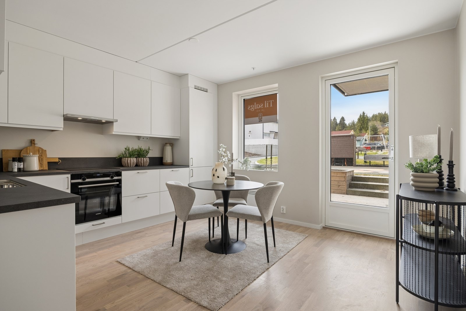 Romslig kjøkken med plass til kjøkkenbord og utgang til stor terrasse. Galleribilde