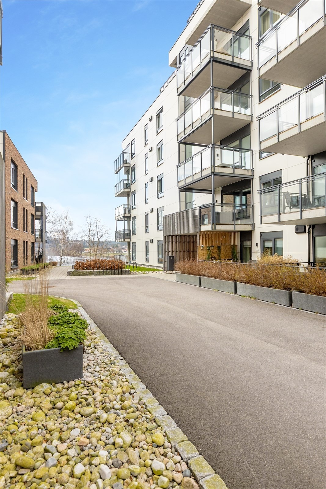 Asfalterte gangveier og pent opparbeidede grøntområder mellom byggene. Galleribilde