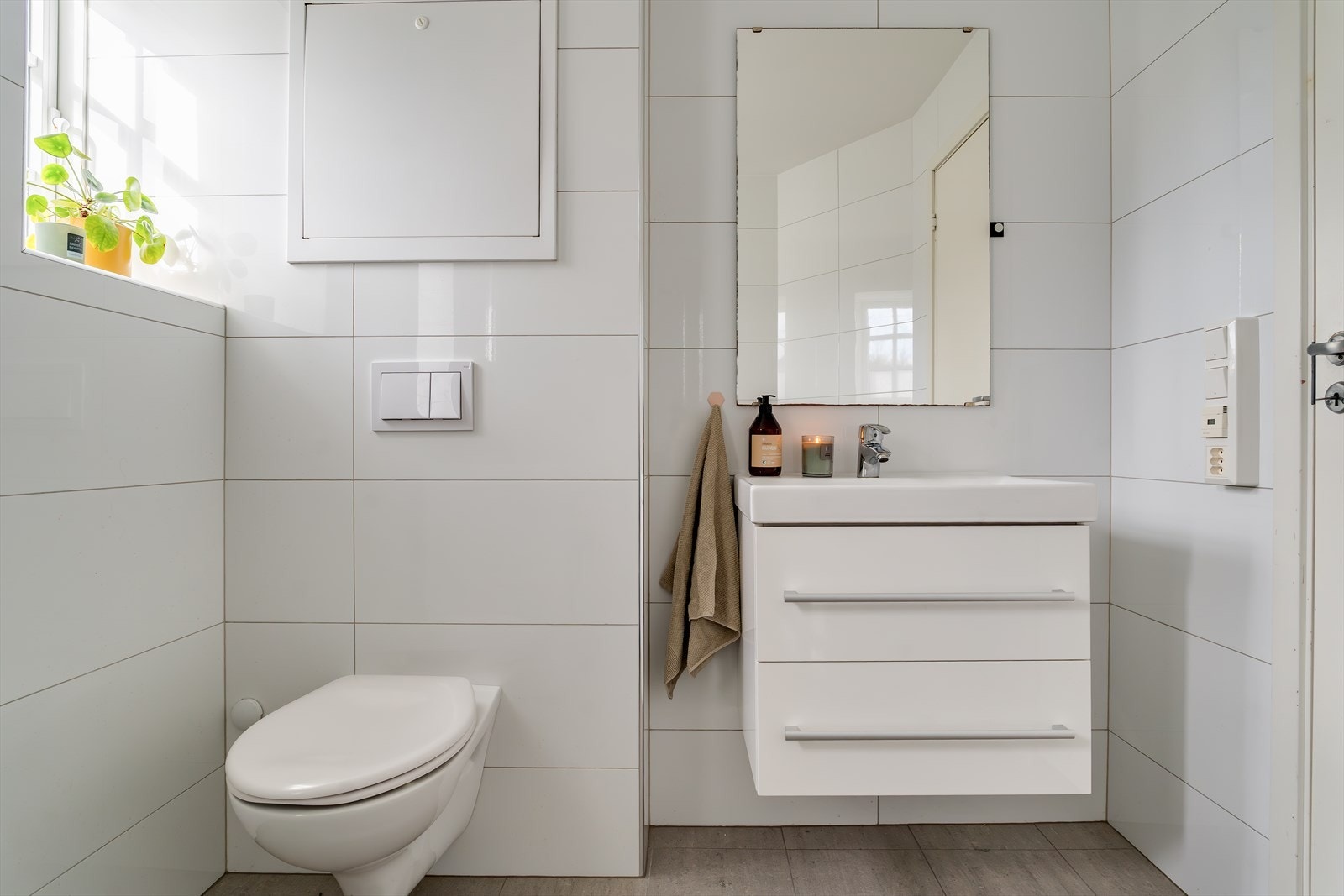 Badet er helfliset og har en moderne innredning med vegghengt toalett. Galleribilde