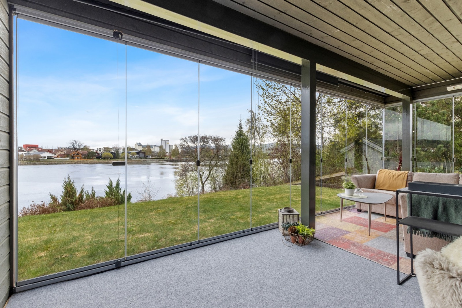 Flott utsikt mot elva via en innglasset terrasse. Galleribilde