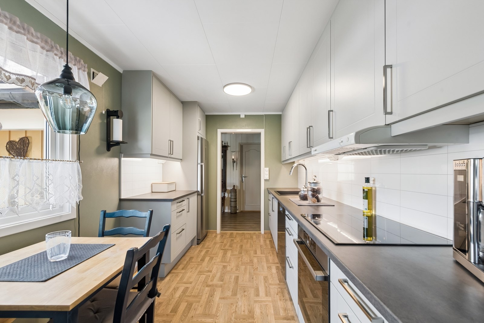 Kjøkkeninnredningen har profilerte fronter, laminat benkeplate og kitchen wall mellom benk og overskap. Galleribilde