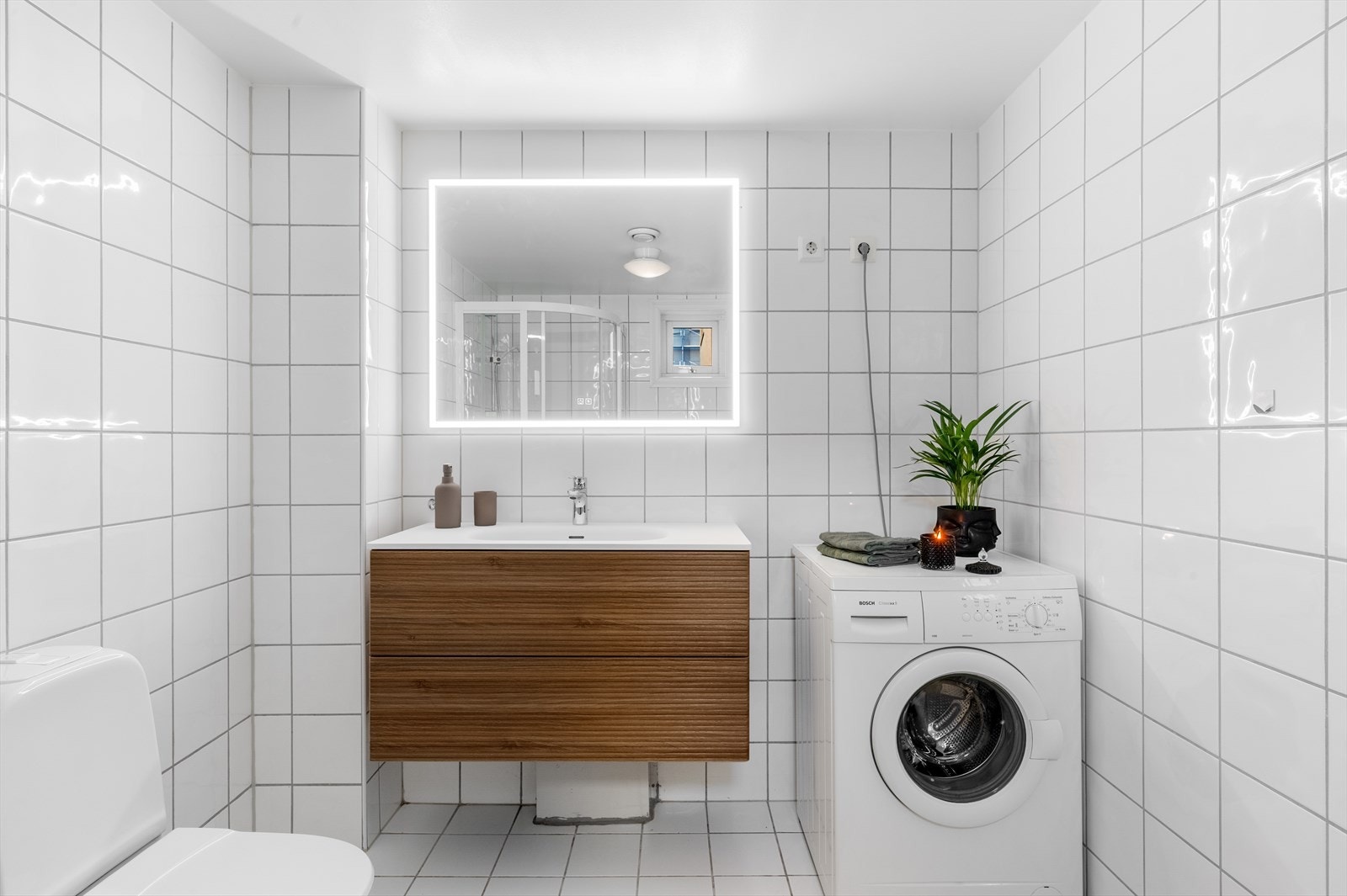 - Badet er innredet med toalett, dusjhjørne, servant med møblement og speil med belysning, med opplegg for vaskemaskin - Galleribilde