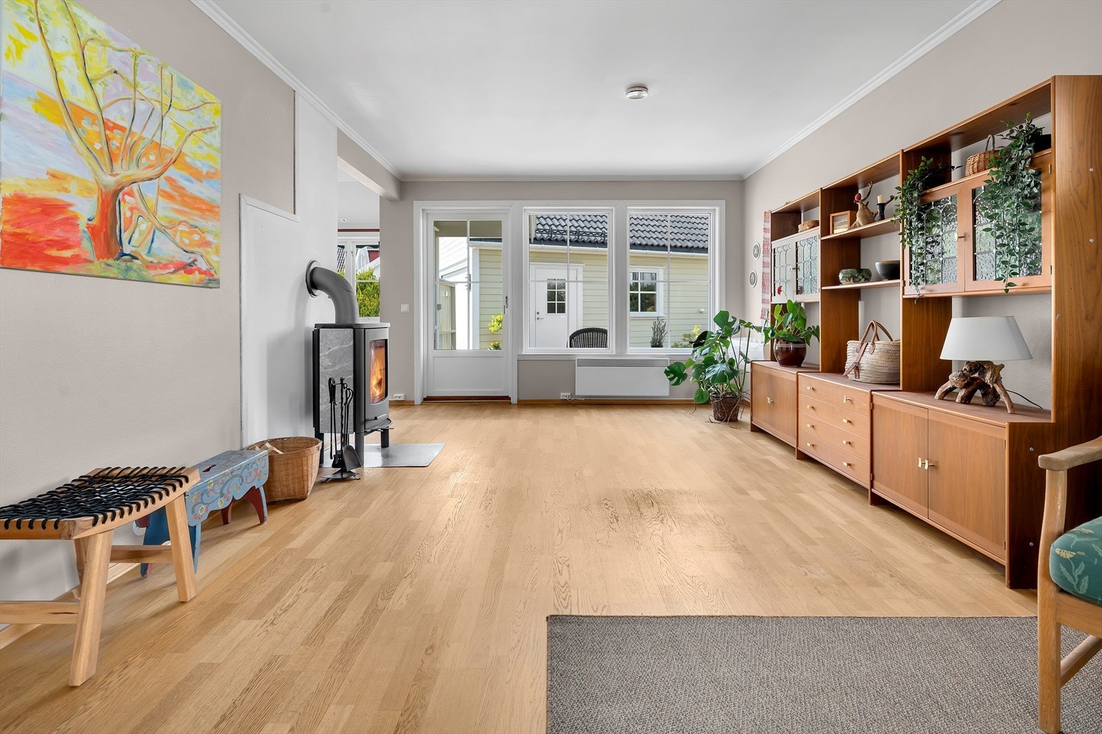 Stue med store vindusflater som gir godt med lysinnslipp samt utgang til uteplass Galleribilde