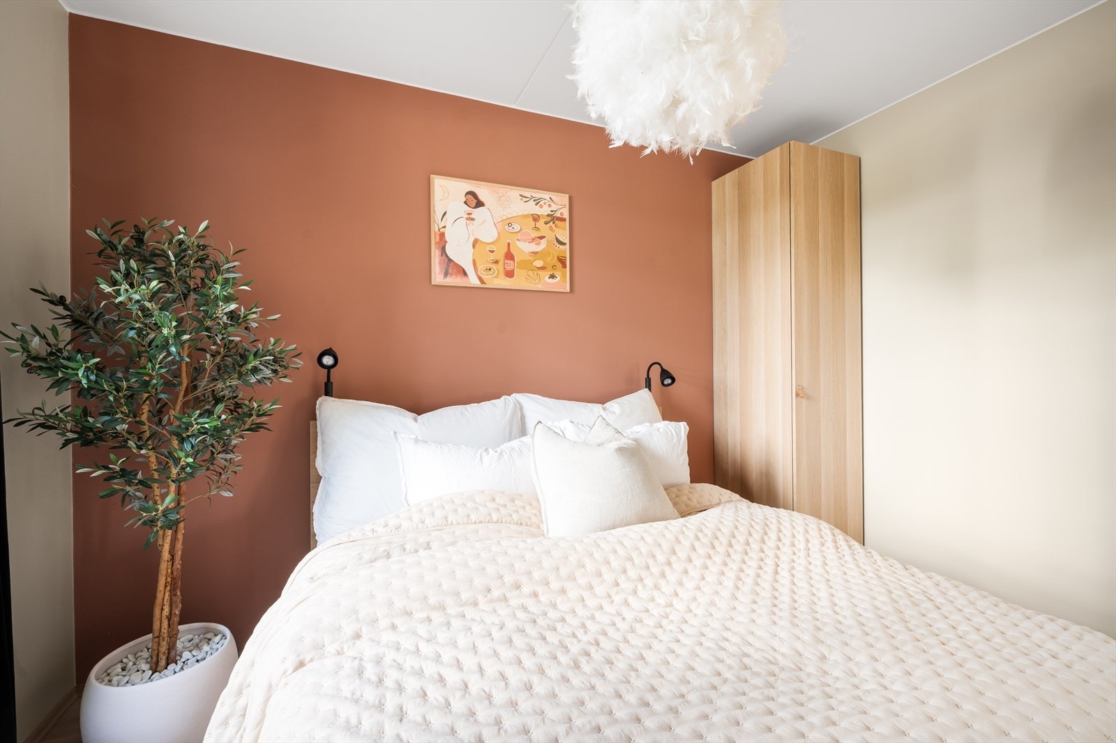 Rommet er malt i lune beige toner med en dekorativ kontrastvegg i burgunder. Galleribilde