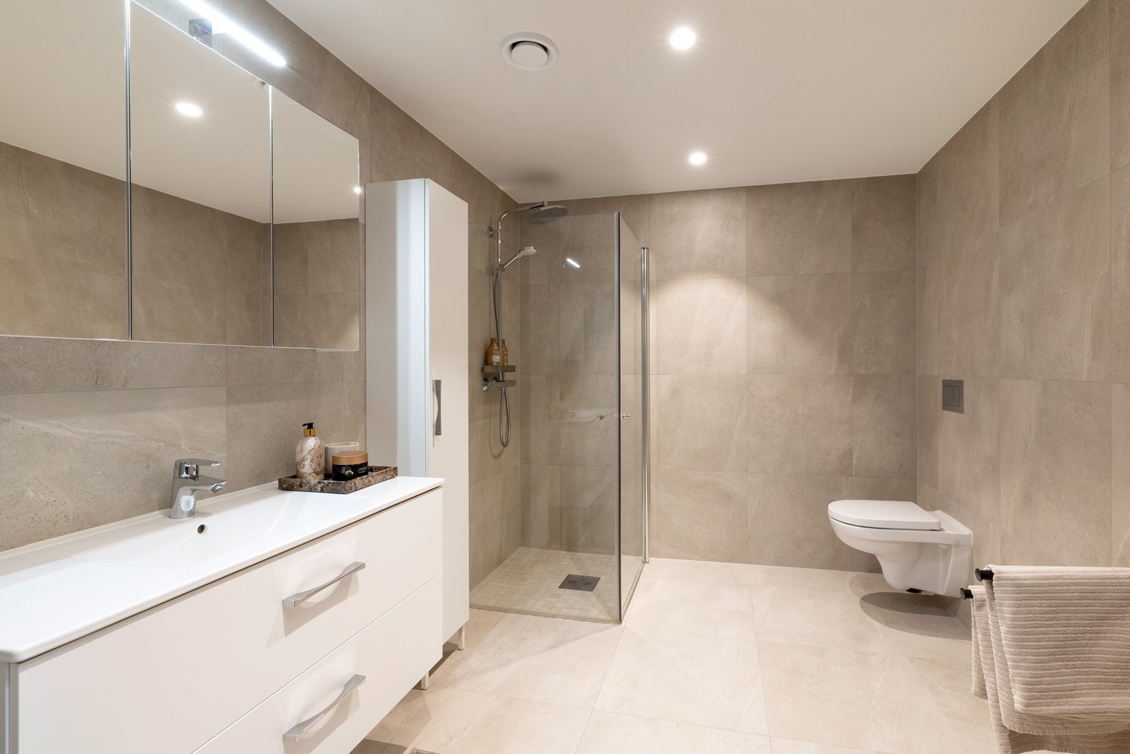 Delikat flislagt bad med 60x60 fliser og varme i gulv. Badet har dusjhjørne, vegghengt toalett samt servant med underskuffer. Galleribilde