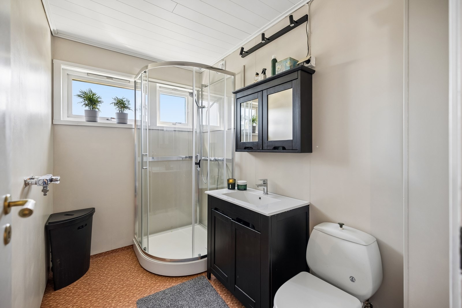 Badet i første etasje er utstyrt med dusjkabinett, servantinnredning og toalett. Rommet har våtromsbelegg på gulv. Galleribilde