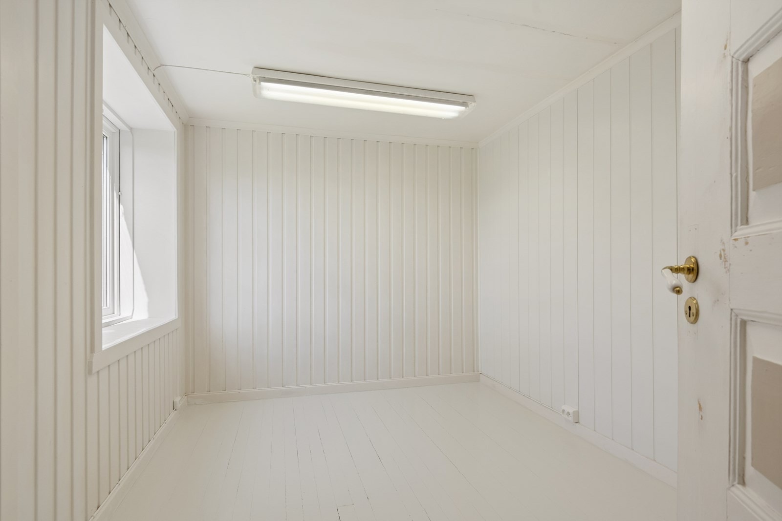 Det andre rommet i kjelleren har malte panelvegger og tregulv. Galleribilde