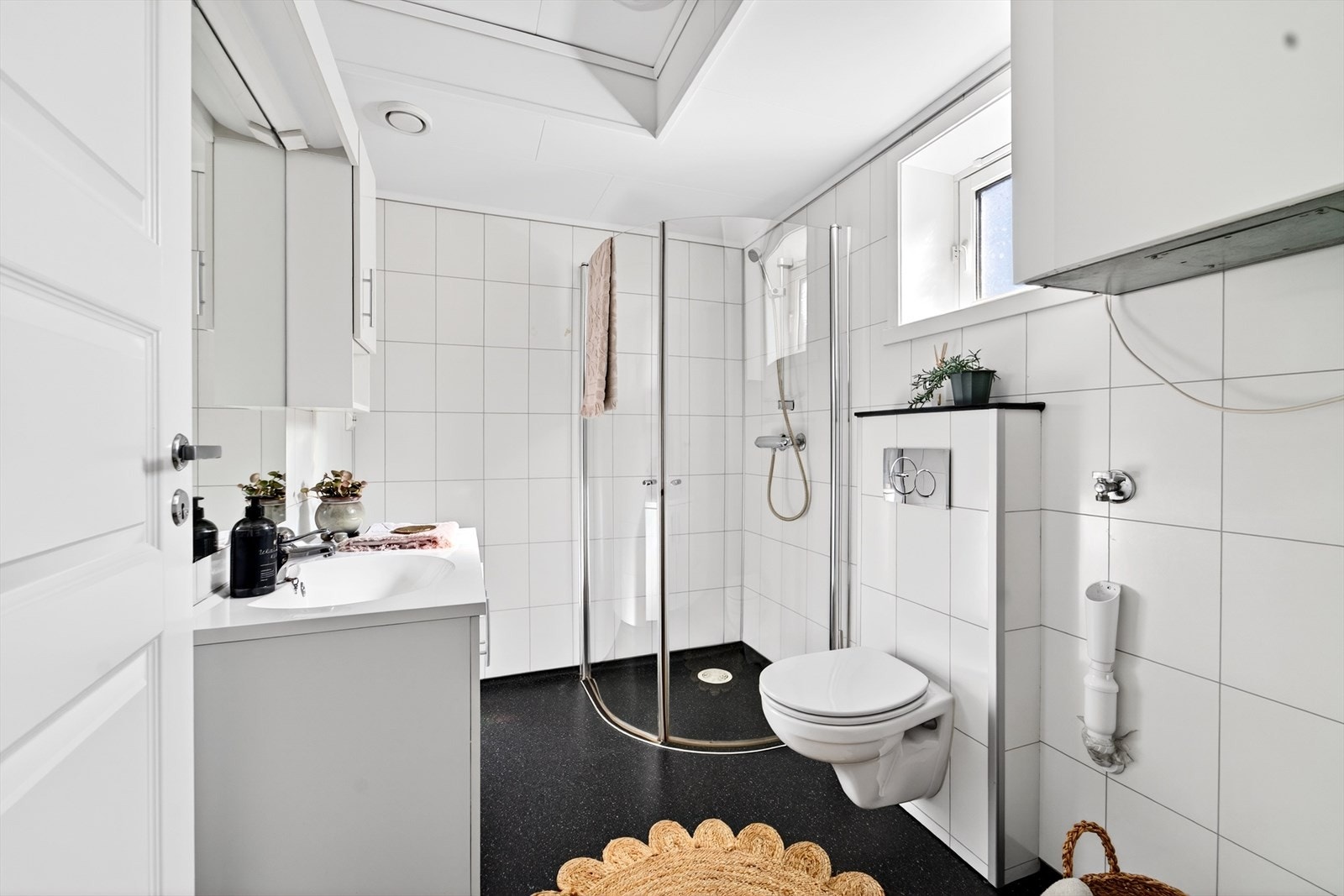 Delikat bad med lys innredning og vegghengt toalett. Opplegg til vaskemaskin. Galleribilde