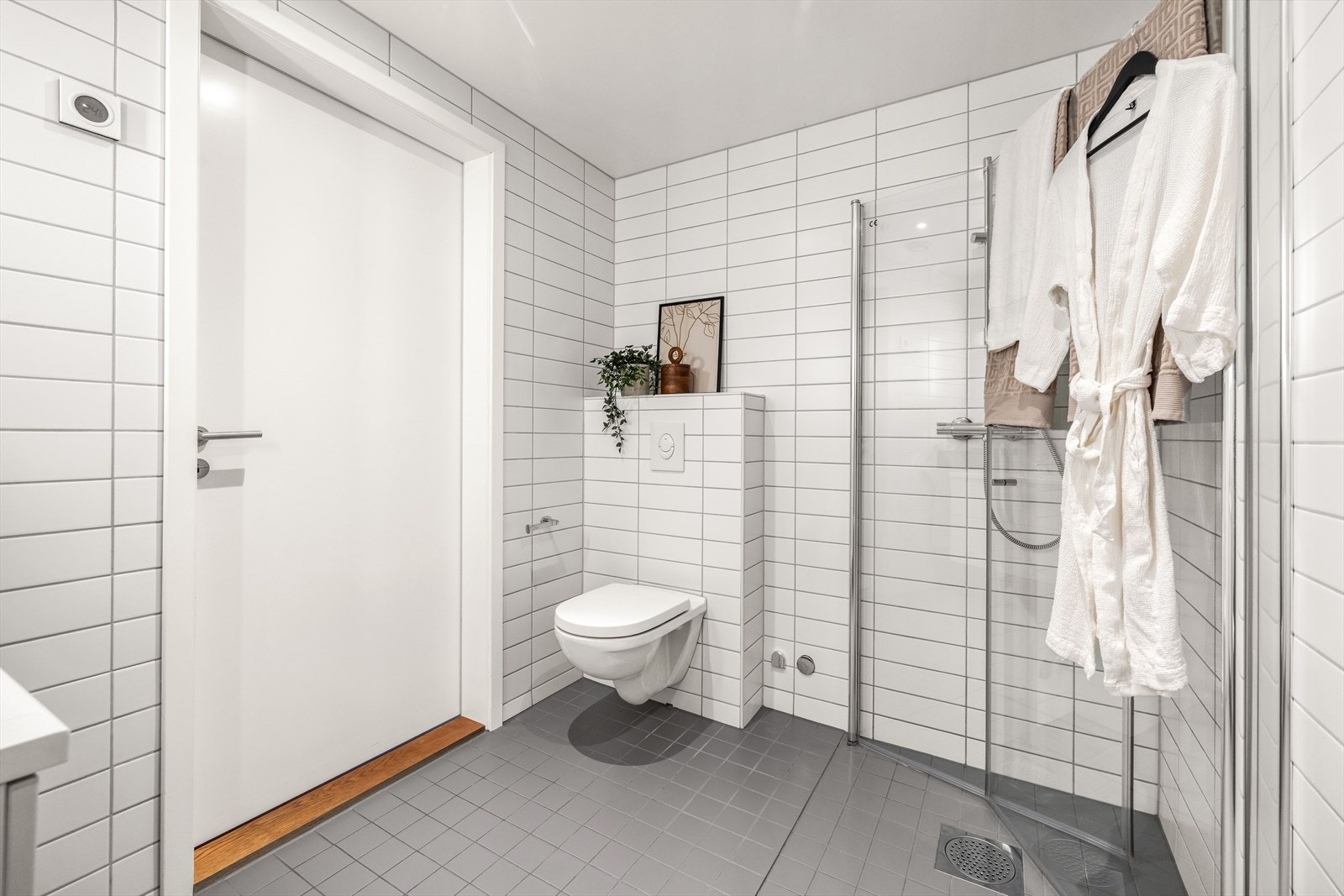 Pent baderom med flislagte overflater, downlightsbelysning og varme i gulvet. Galleribilde