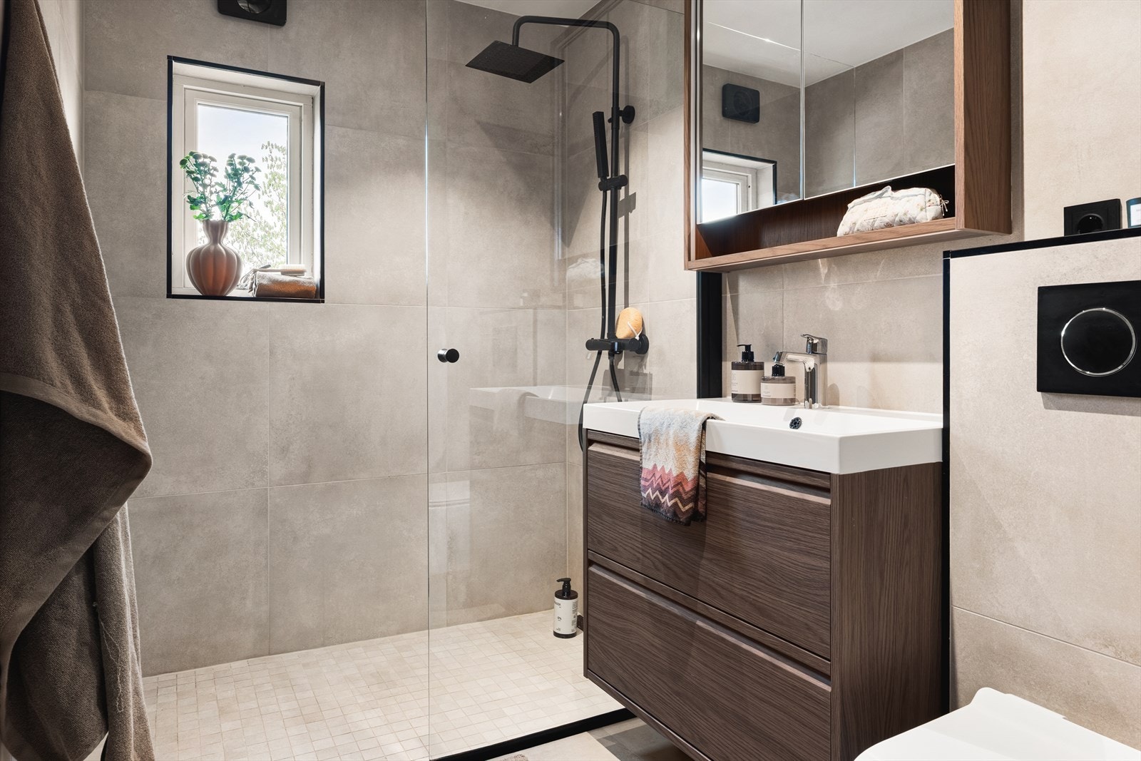 Bad fra 2023. Badet er utstyrt med vegghengt toalett, dusj med glassvegger og baderomsinnredning. Galleribilde