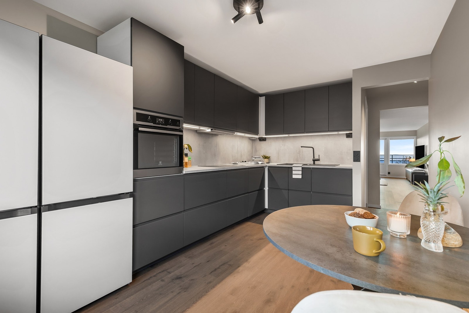 Kjøkken med innredning fra 2023. Glatte fronter. Benkeplate med laminert overflate. Kjøkkenvask med armatur. Integrert stekeovn, platetopp og oppvaskmaskin. Galleribilde