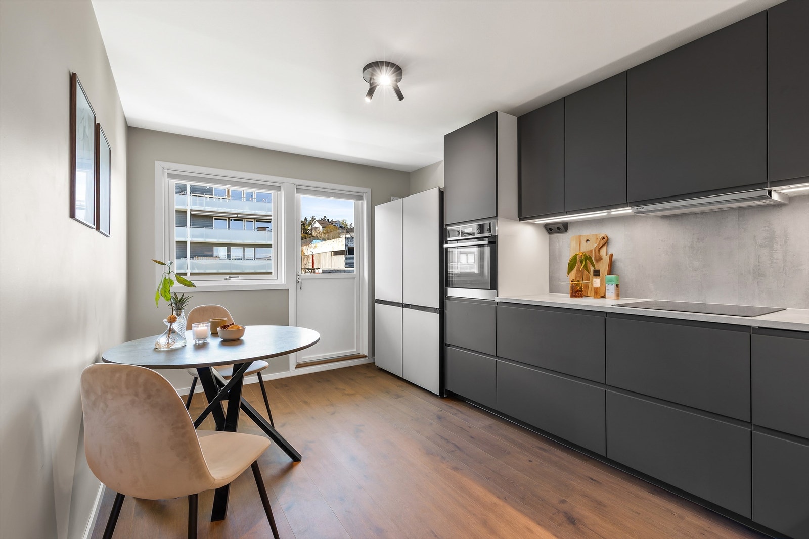 Nyoppusset, moderne kjøkken med integrerte hvitevarer og utgang til balkong. Plass til mindre spisegruppe. Foto: Trond Reder Galleribilde