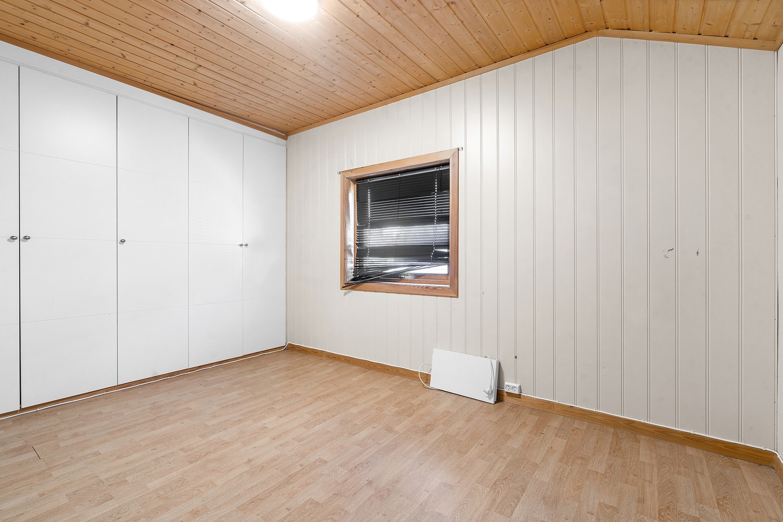Soverom i første etasje med garderobeskap. Rommet har trepanel i himling og laminat på gulv. Galleribilde