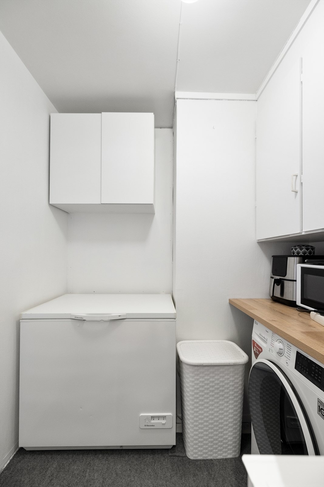 Separat vaskerom med opplegg for vaskemaskin og praktisk oppbevaring. Galleribilde