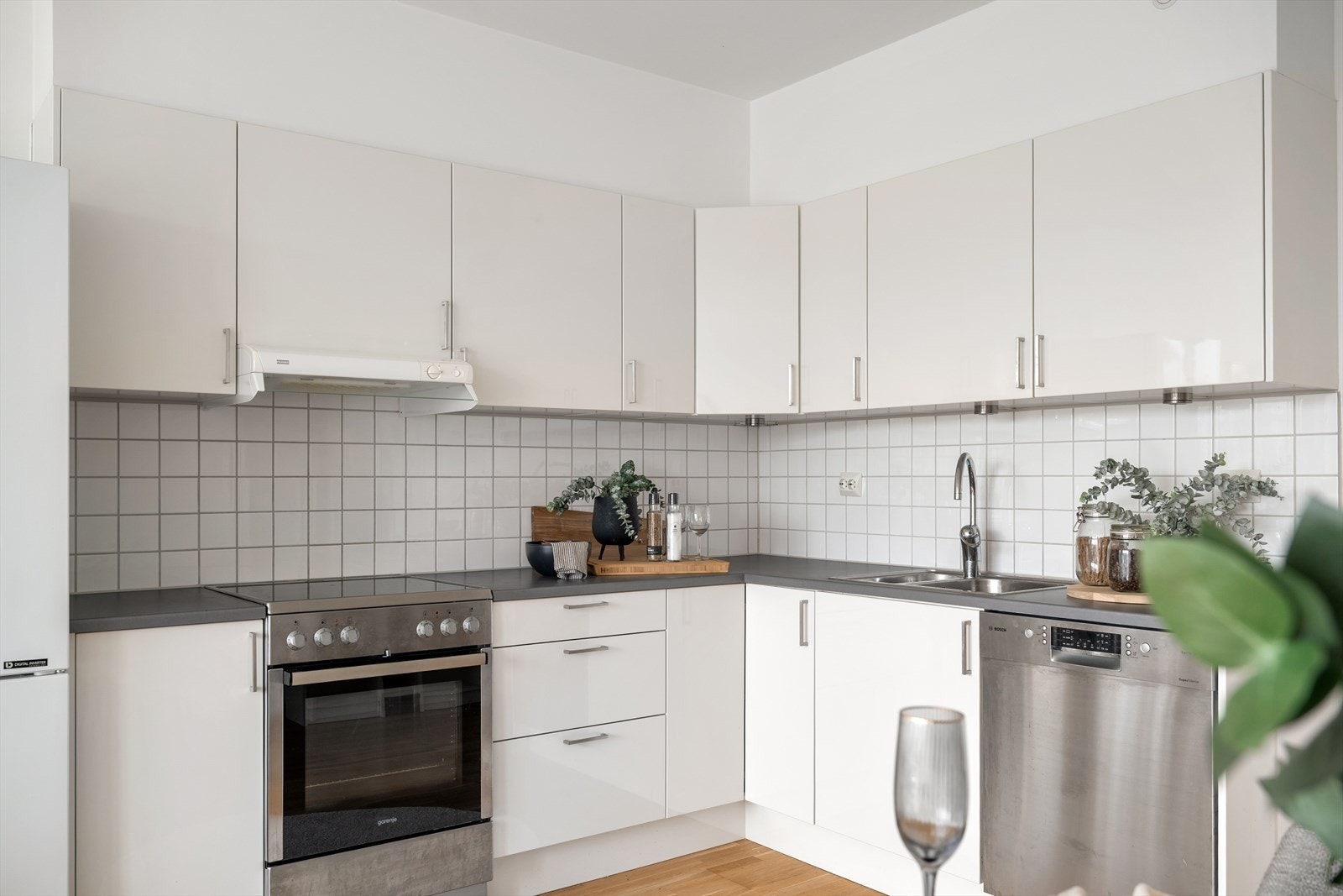 Kjøkkenet har en tidløs innredning med hvite, glatte fronter og laminat benkeplate. Galleribilde