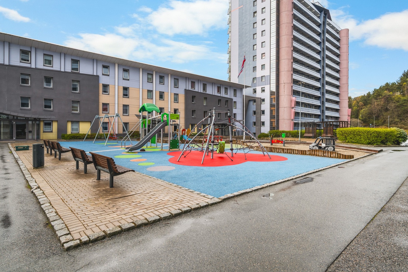 Stor felles tomt som er pent opparbeidet med parkeringsarealer, grønt områder, lekeplasser, sittegrupper og variert beplantning. Galleribilde