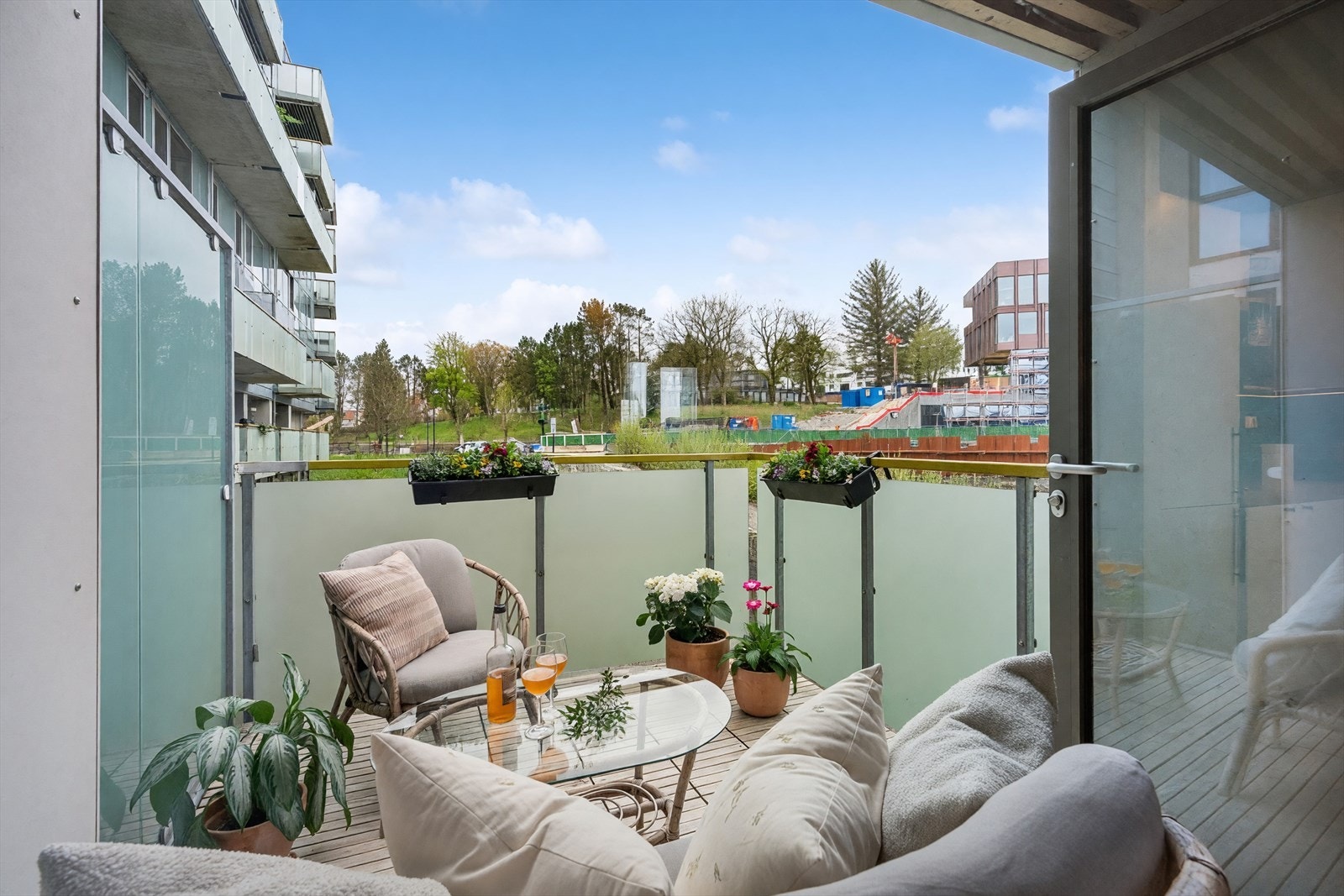 Balkongen har terrassebrikker på dekket og rekkverk i metall og glass. Galleribilde