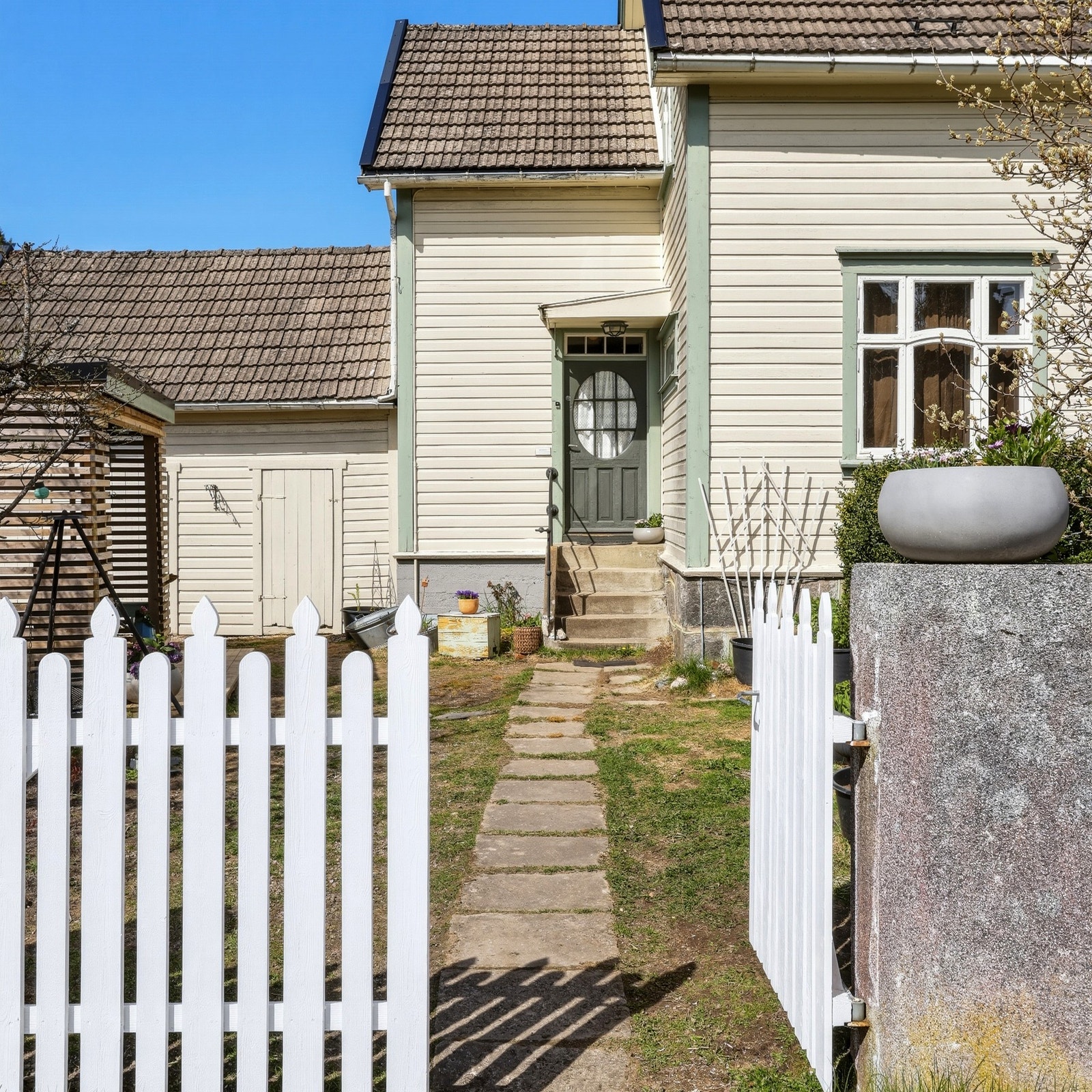 Eiendommen har en hyggelig overbygget inngangsparti med betong trapp til hoveddør. Hoveddøren er utsmykket med historisk vindusglass som gir et godt første inntrykk. Galleribilde