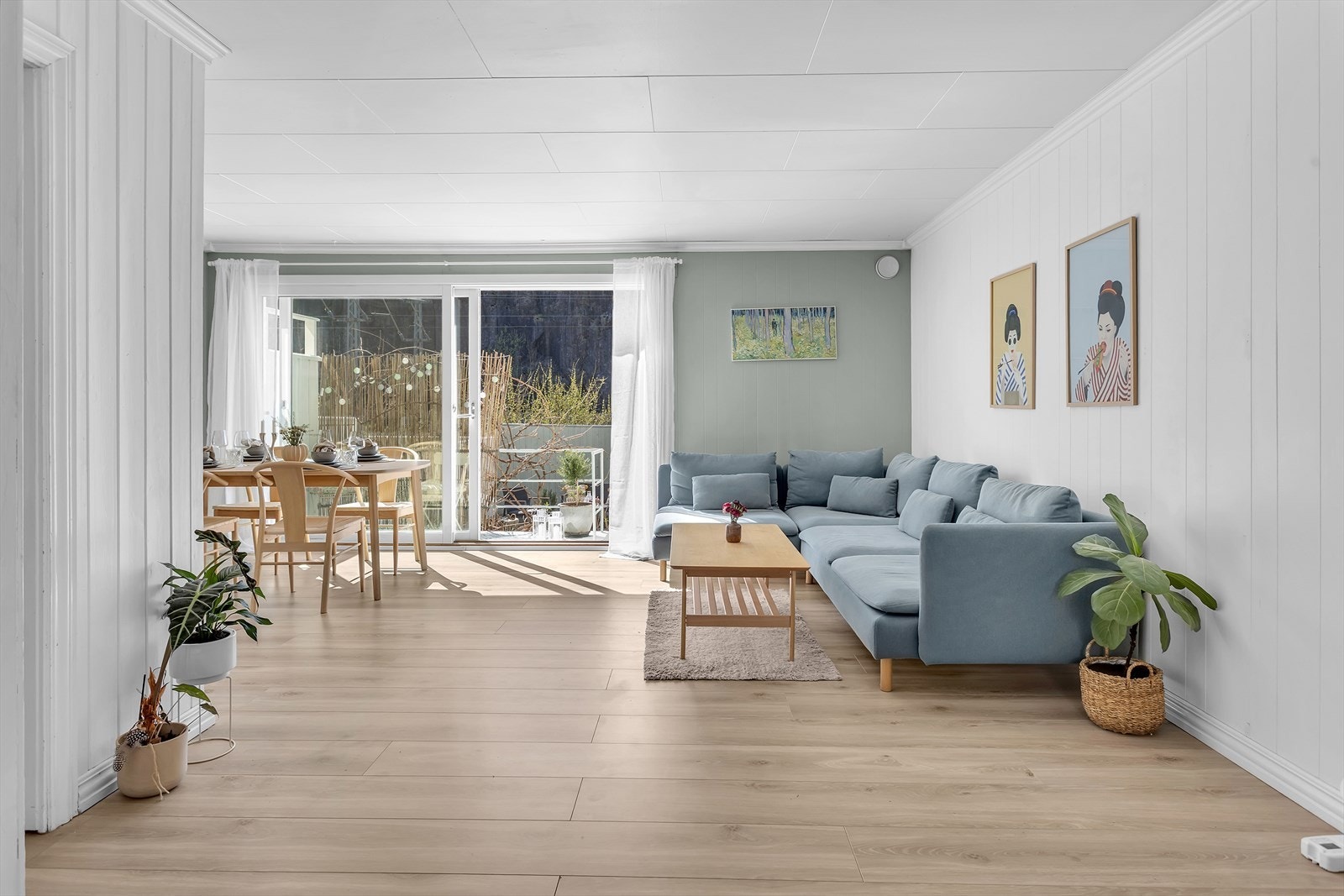 Lys og romslig stue med moderne fargevalg, perfekt tilpasset både et komfortabelt salongområde og et stilfullt spisestuemøblement i naturlig avdelte soner. Galleribilde