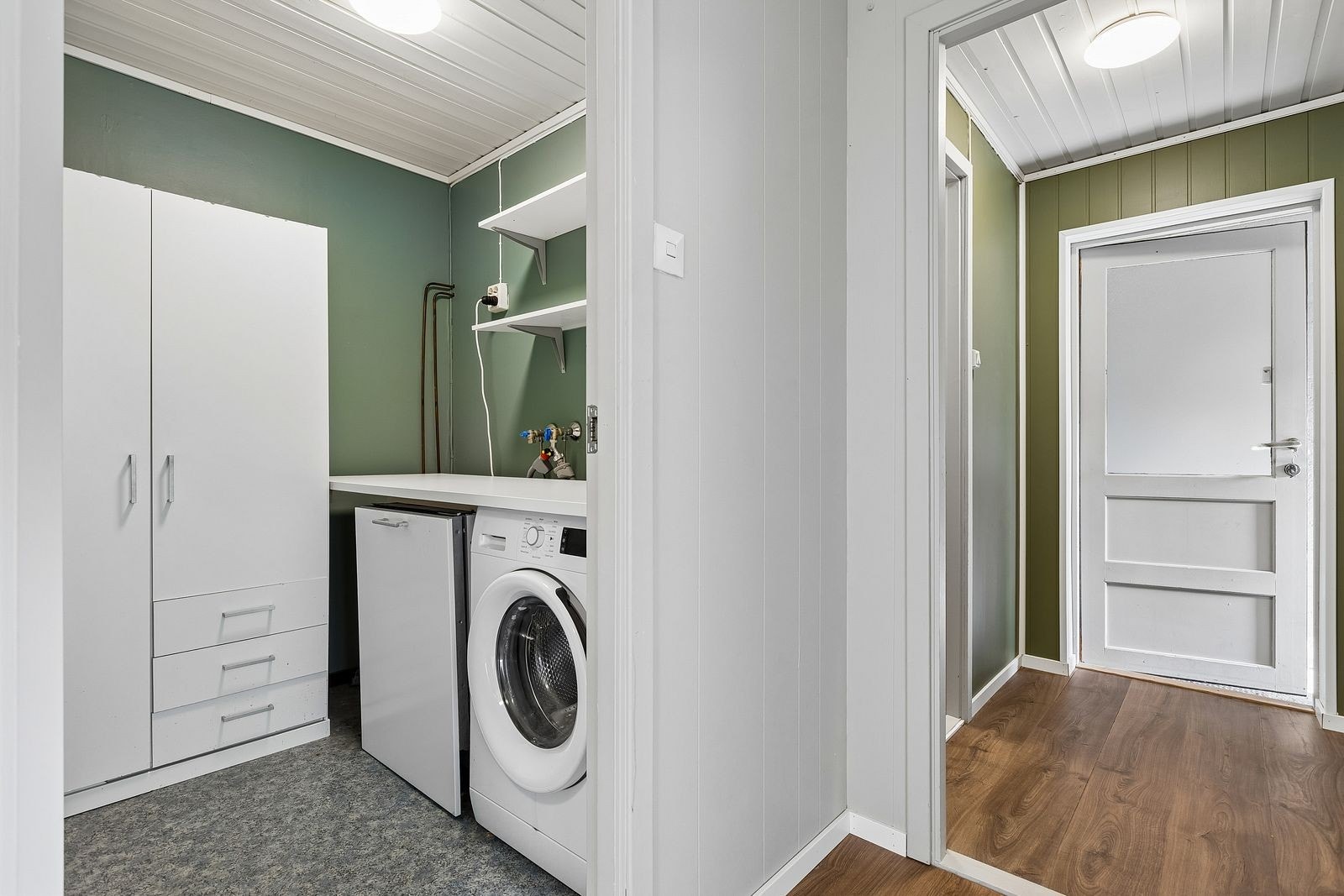 Eget vaskerom med oppvaskmaskin og vaskemaskin. Innredet med garderobeskap. Galleribilde