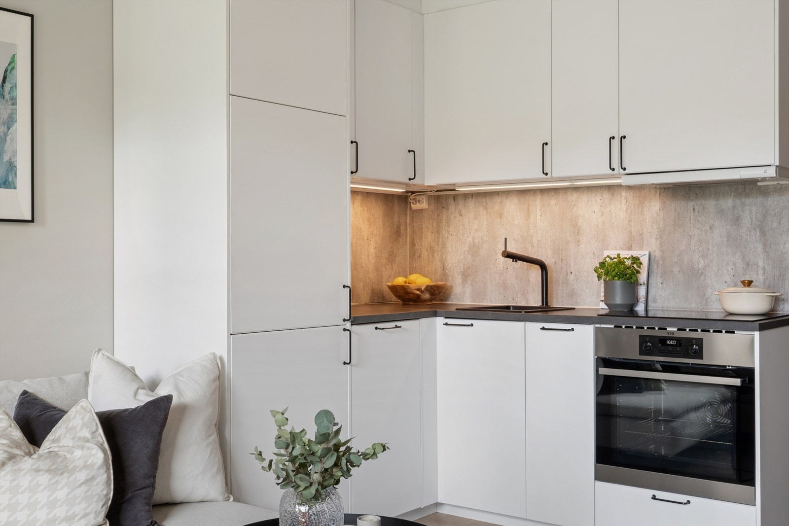 Kjøkkeninnredningen består av glatte hvite fronter med svarte detaljer. Galleribilde
