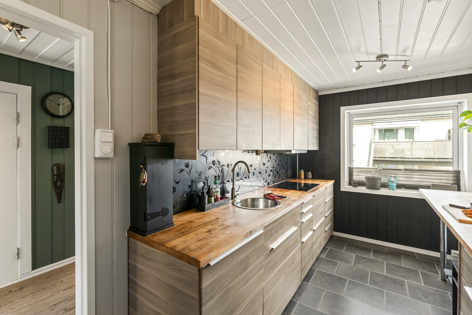 Kjøkkeninnredning med slette fronter i trestruktur og benkeplate i heltre. Galleribilde