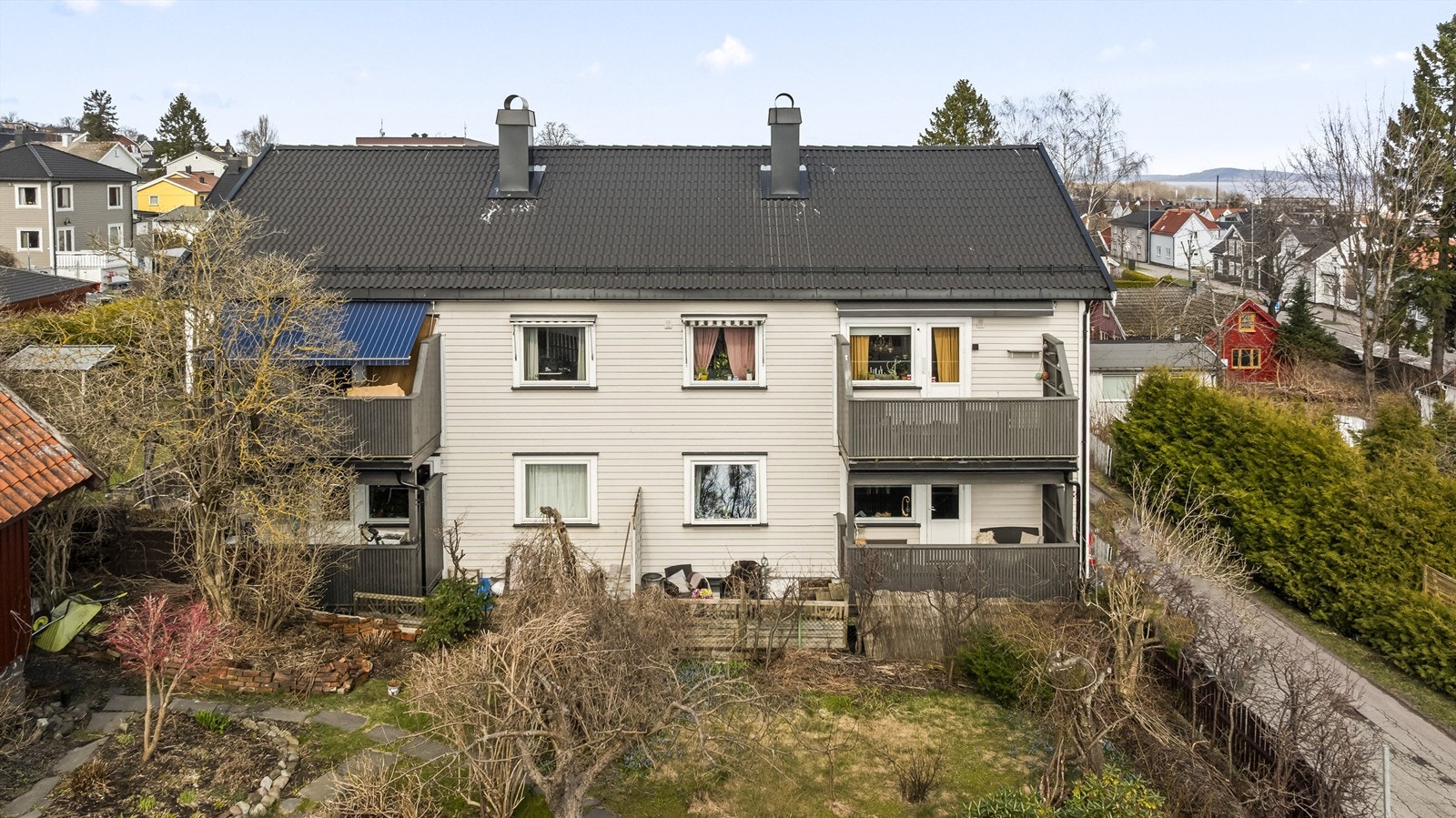 Fasaden mot naboens hagen, hvor man ser leilighetens veranda. Galleribilde
