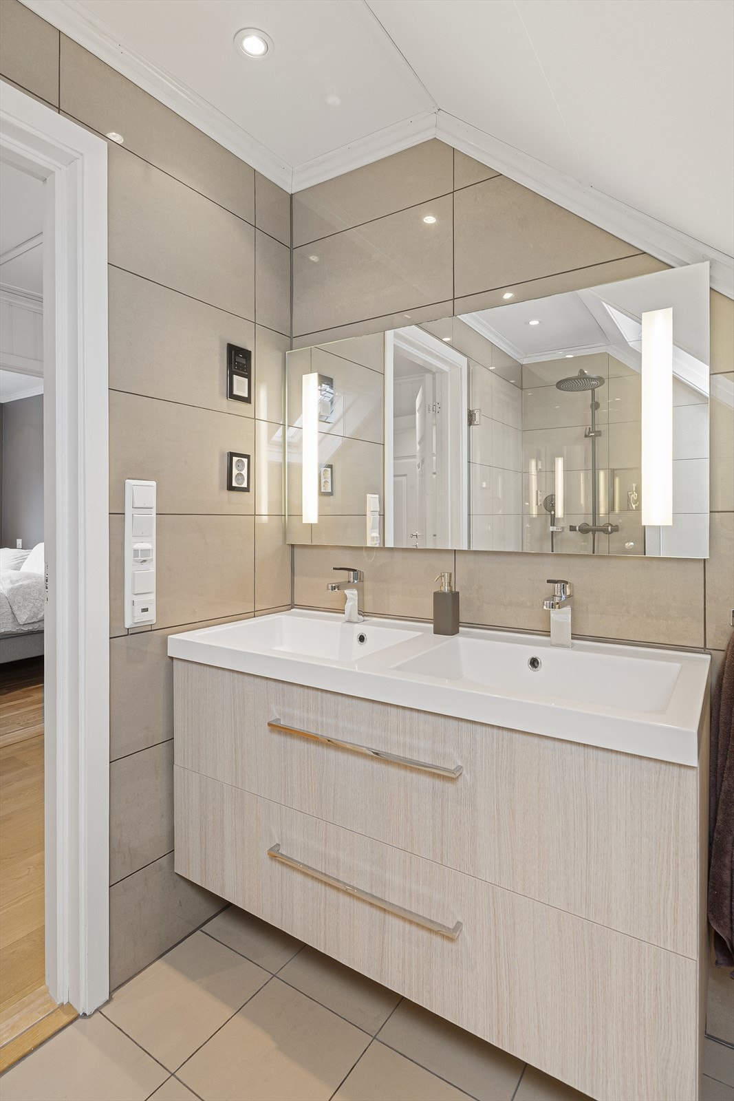 Badet er innredet med baderomsinnredning, vegghengt toalett og dusjnisje med glassvegg, og har elektrisk styrt avtrekksvifte Galleribilde
