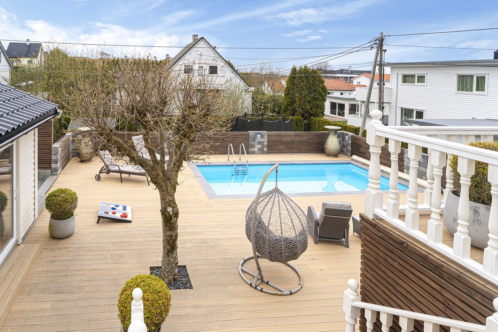 Det herlige terrasseområdet har rekkverk med søyler av stablede betongblokker (kubbemur) og innfelte felt med horisontale trespiler - rekkverket og spiler ble malt og oljet i 2025 Galleribilde
