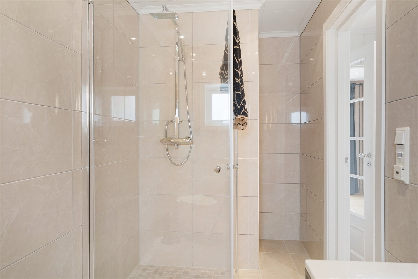 Badet er innredet med moderne baderomsinnredning, vegghengt toalett og dusjnisje med glassvegger Galleribilde
