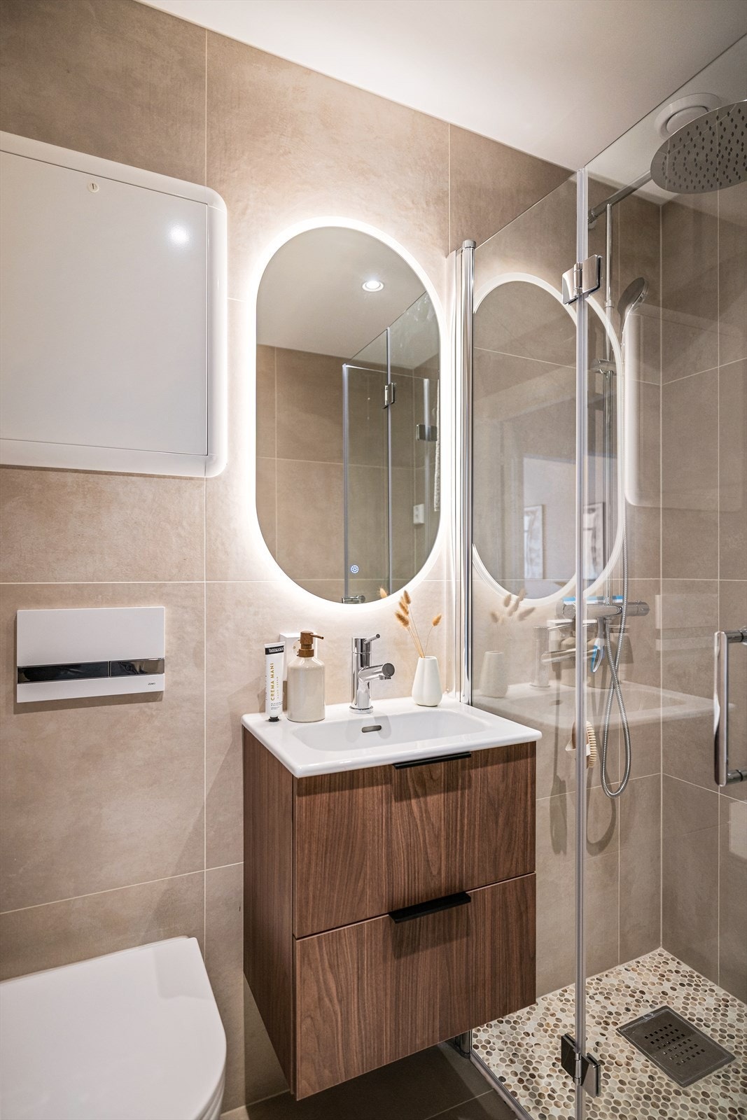 Badet er utstyrt med servant, veggmontert toalett og dusjvegger. Praktisk med opplegg for vaskemaskin på badet. Galleribilde