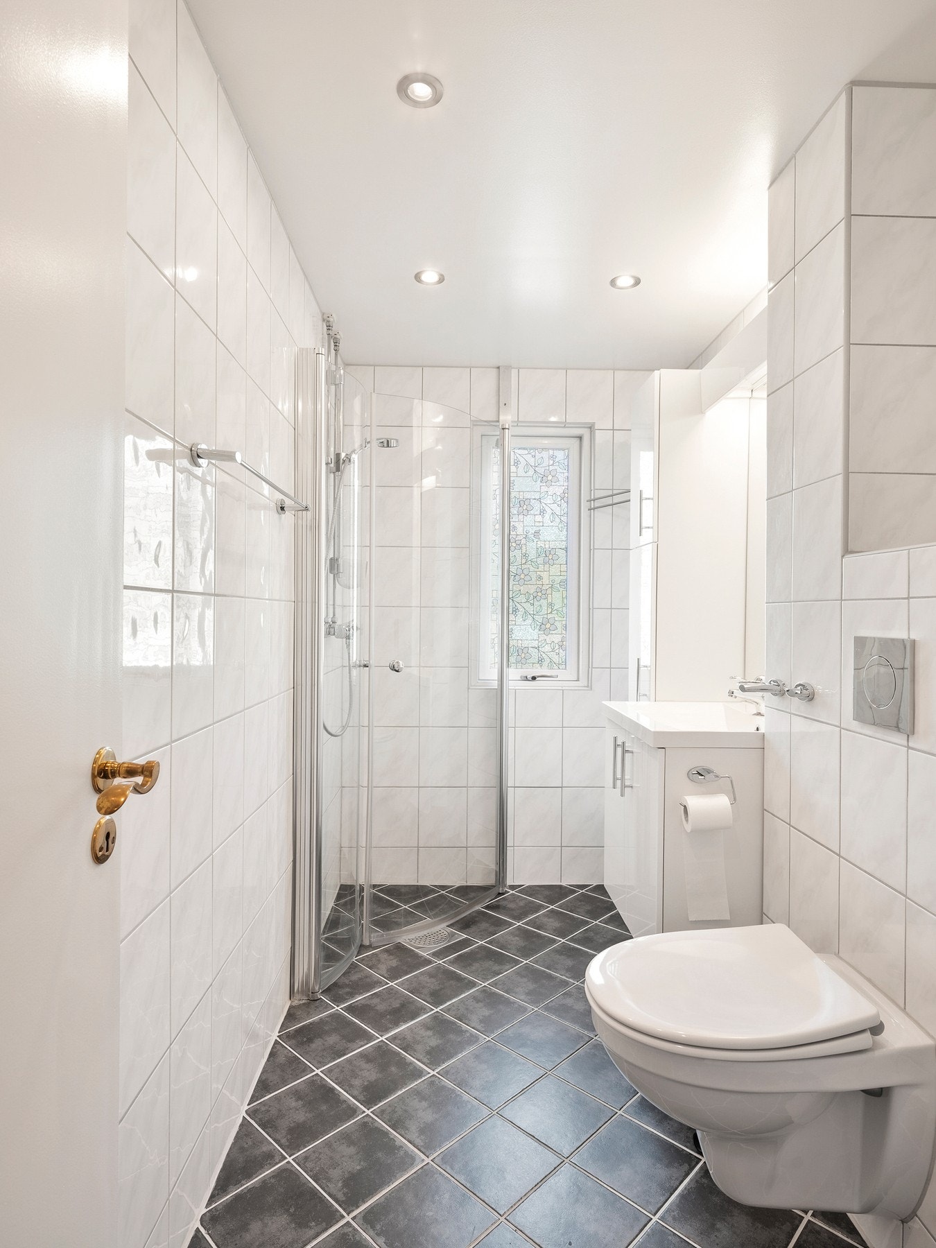 Badet har flislagte gulv og- veggflater, samt et hvitmalt, slett tak. Det er installert varmekabler i gulvet og spotlights i taket, samt lys integrert i speil. Galleribilde