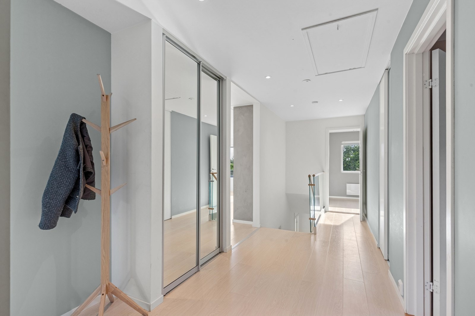 God plass til å henge fra seg ytterklær i skyvedørsgarderobe med speil og innredning. Galleribilde
