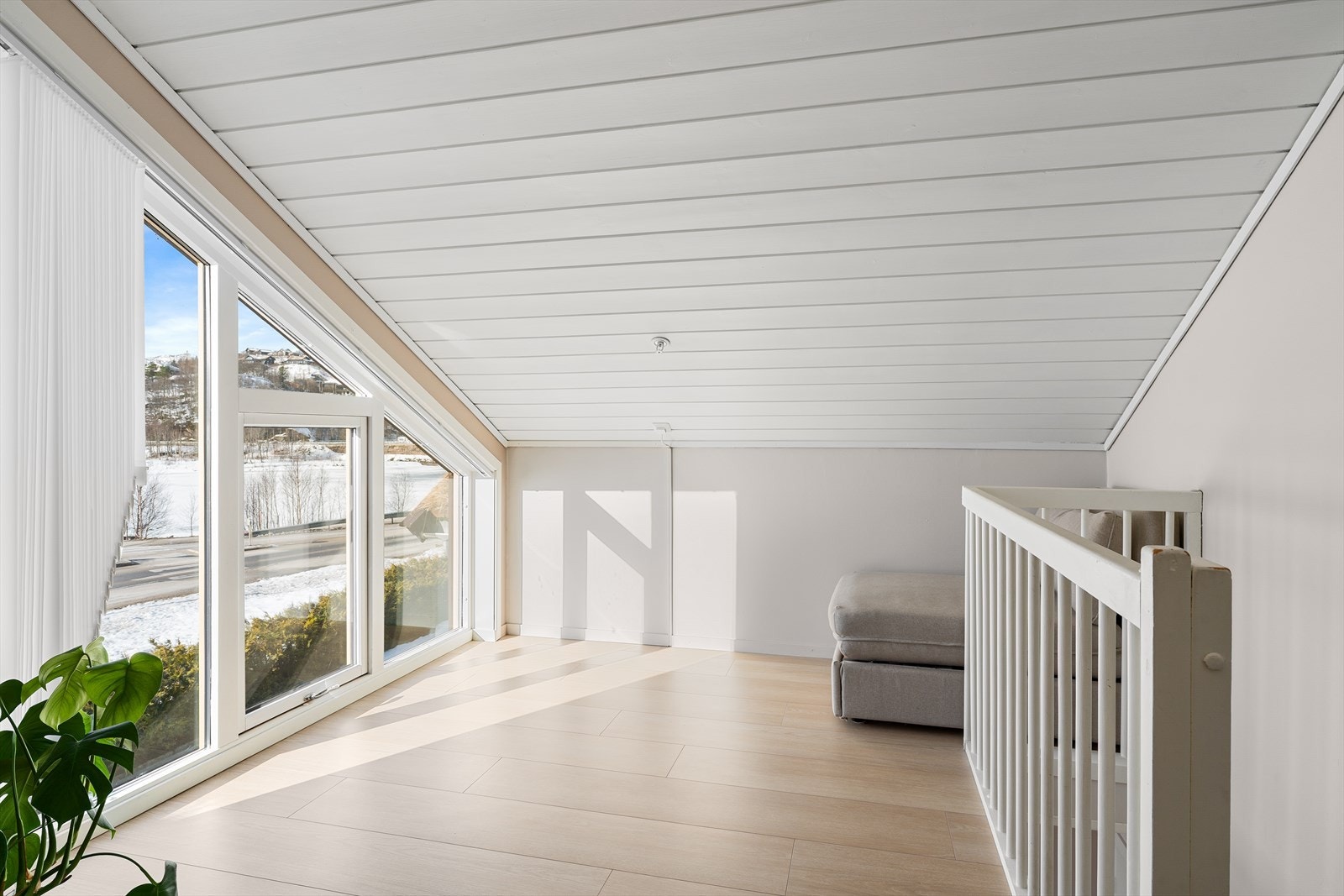 Fin loftstue med stort vindu fra gulv til tak, slipper inn naturlig lys og gir fin utsikt. Galleribilde