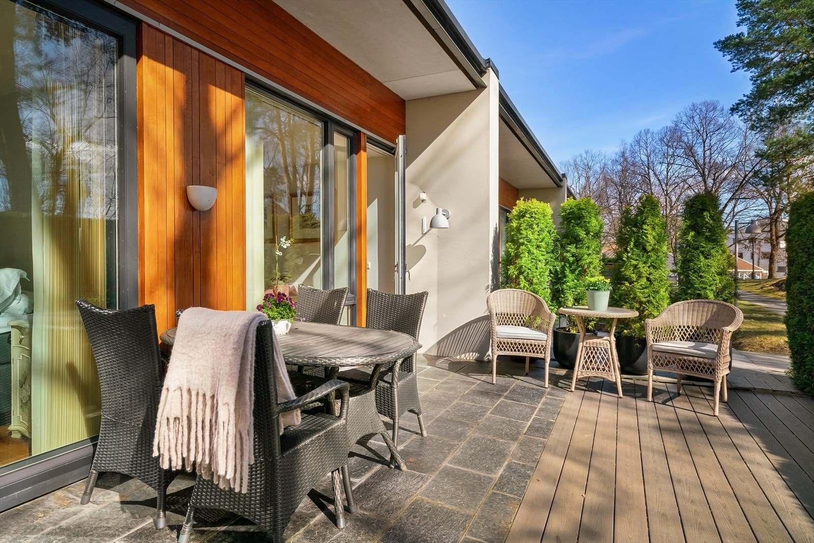 Solrik terrasse som er belagt med heller og treverk. Galleribilde